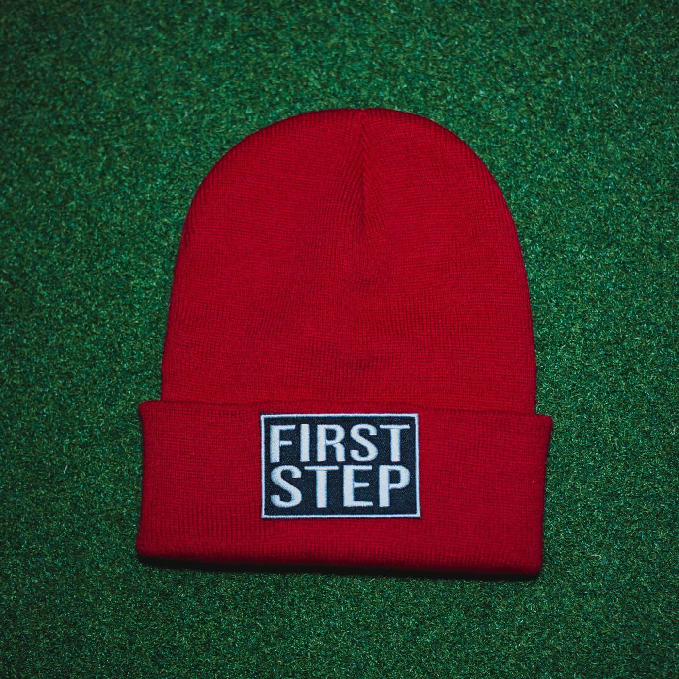 Red Beanie with a First Step Apparel Patch Sewn on